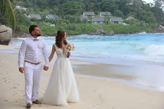 Anthony et Maëva, mariés aux Seychelles, main dans la main sur la plage